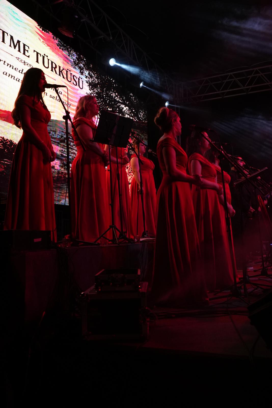 Kırmızı sahne kıyafetleriyle konser veren koro üyeleri