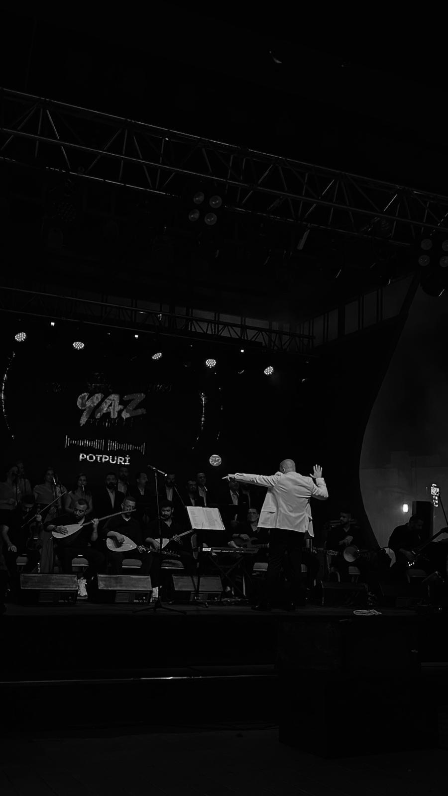 Şefin koro ve orkestrayı yönettiği siyah beyaz konser fotoğrafı
